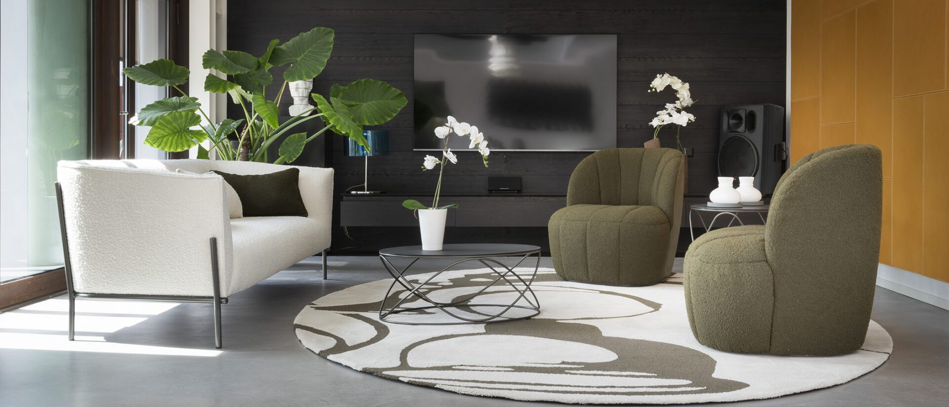 a living room with a large round rug and chairs